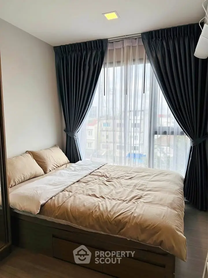 Cozy bedroom with large window and elegant curtains in modern apartment