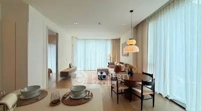 Spacious modern living room with dining area and large windows in a stylish apartment.