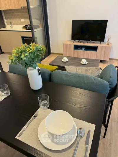 Modern living room with stylish decor, open kitchen, and cozy seating area, perfect for urban living.