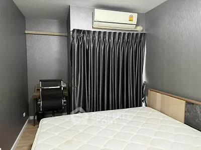 Modern bedroom with sleek design, featuring a comfortable bed and a compact study area.