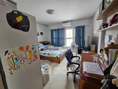Cozy bedroom with natural light, featuring a bed, desk, and personal decor, ideal for comfortable living.