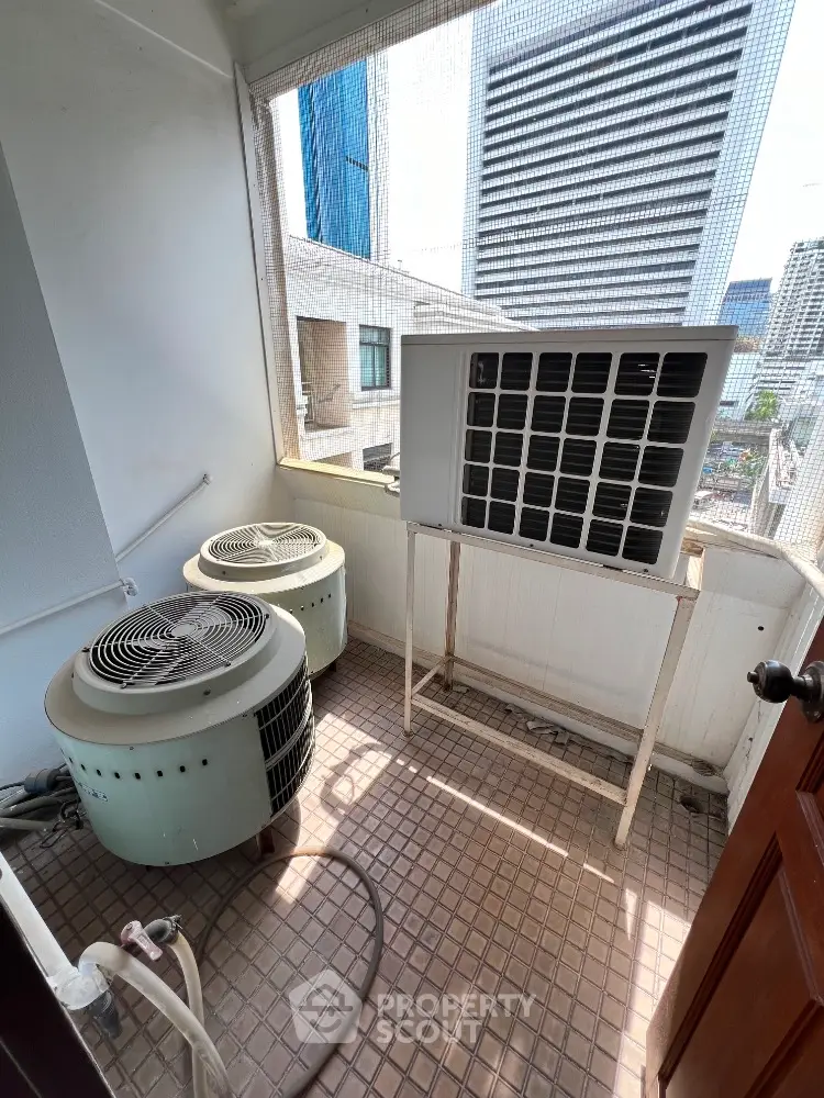 Urban balcony with air conditioning units and city view