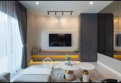 Modern living room with stylish decor and large TV, featuring elegant furniture and ambient lighting.