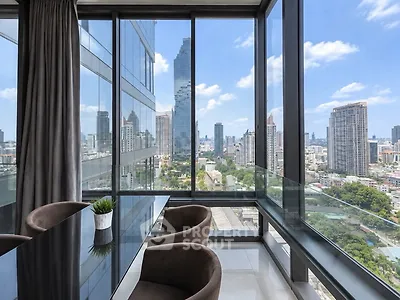 Stunning city view from modern high-rise apartment with floor-to-ceiling windows.