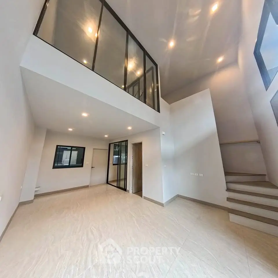 Spacious modern interior with high ceilings and mezzanine, perfect for stylish urban living.