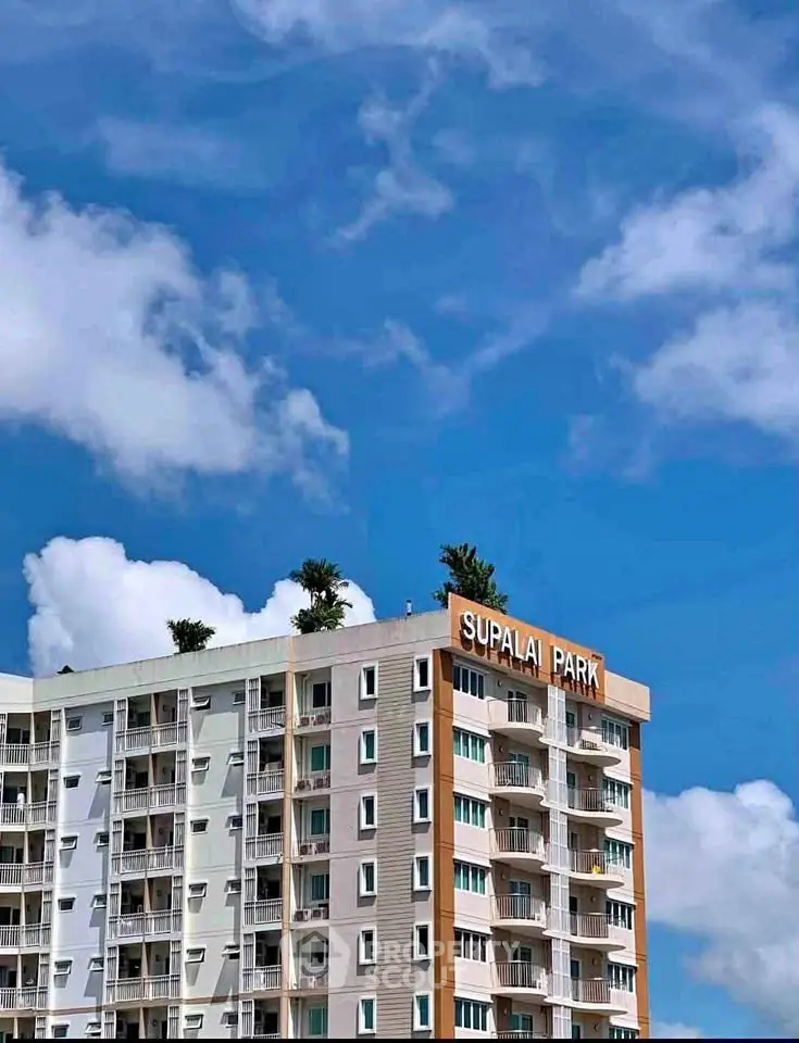 Modern apartment building with clear blue sky background, showcasing Supalai Park's contemporary architecture.