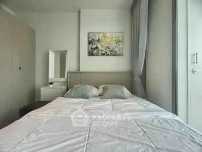 Modern bedroom with stylish decor and natural light, featuring a cozy bed and elegant artwork.