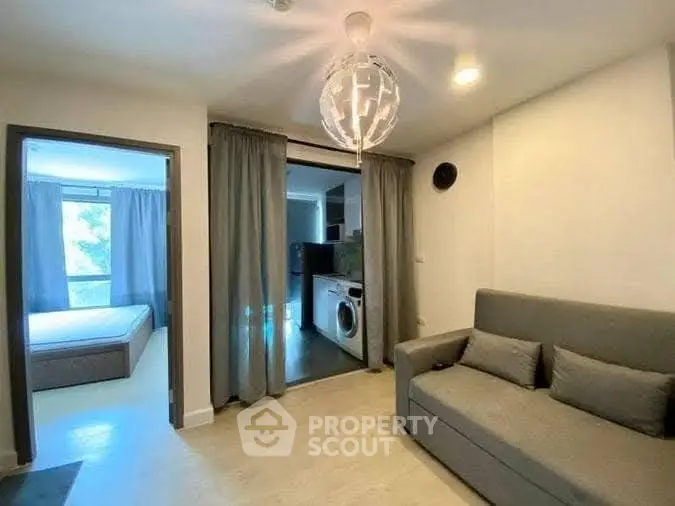 Modern living room with cozy sofa and washing machine in open layout apartment.