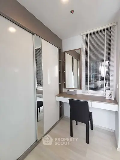 Modern study room with sleek desk and chair, large mirror, and ample storage space.