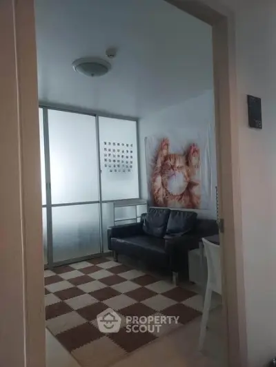 Cozy small living room with modern decor and large cat artwork, perfect for relaxation.