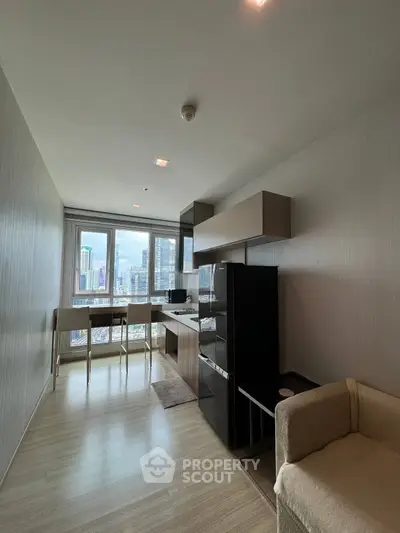Modern kitchen with city view, featuring sleek appliances and open layout in a high-rise apartment.