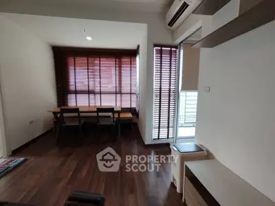 Modern living room with wooden flooring and stylish blinds, featuring a cozy dining area and air conditioning.