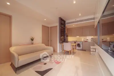 Modern living room with open kitchen, featuring a cozy sofa and stylish decor, perfect for urban living.