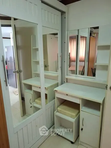 Compact bedroom with mirrored wardrobe and desk in cozy apartment