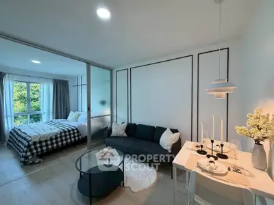 Modern studio apartment with stylish living area and cozy bedroom, featuring elegant decor and natural light.