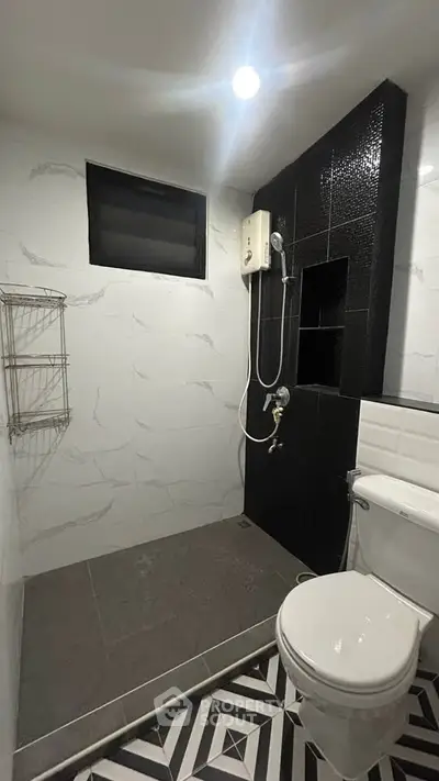 Modern bathroom with stylish black and white tiles and shower area