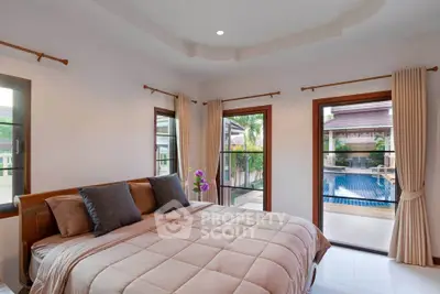 Luxurious bedroom with pool view and elegant decor in a modern home.