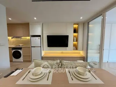 Modern open-plan kitchen and living area with stylish dining setup and built-in appliances.
