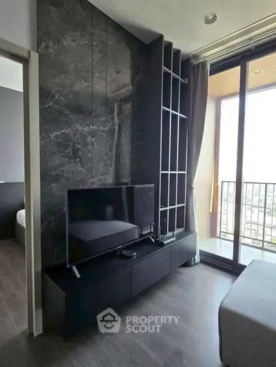 Modern living room with sleek black TV unit and floor-to-ceiling windows offering city views.