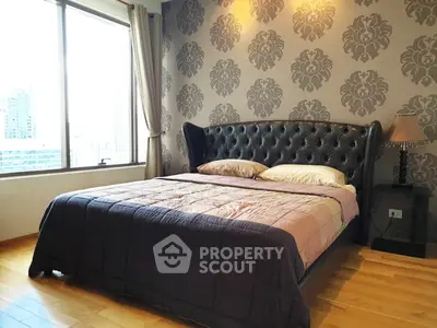 Luxurious bedroom with elegant wallpaper and city view, featuring a plush bed and hardwood flooring.