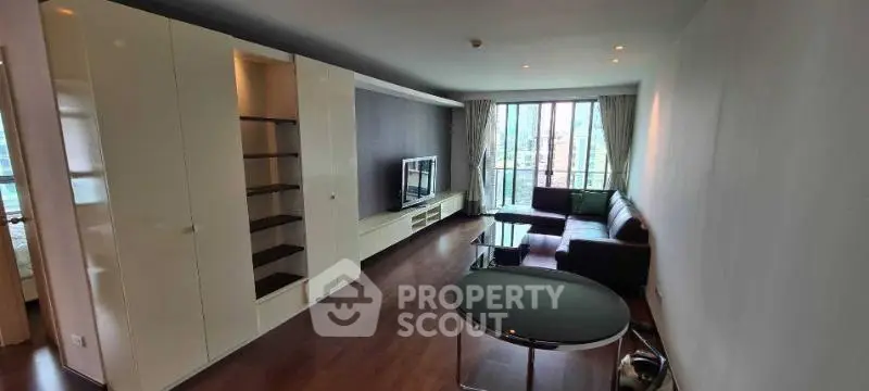 Spacious modern living room with sleek furniture and large windows offering natural light.