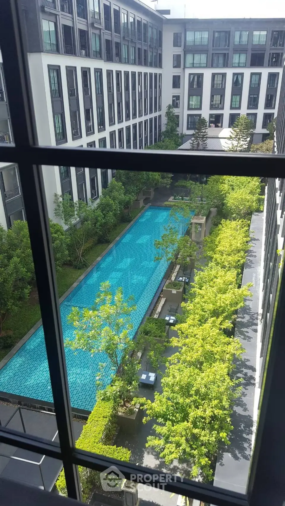 Luxurious apartment complex with a stunning pool view and lush greenery, perfect for modern living.