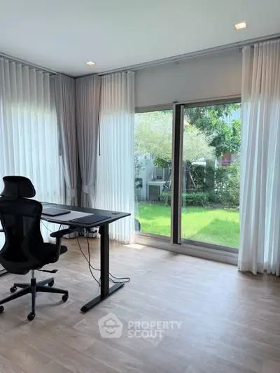 Modern home office with garden view and ergonomic chair