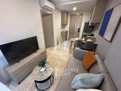 Modern living room with cozy sofa, TV, and dining area in stylish apartment.