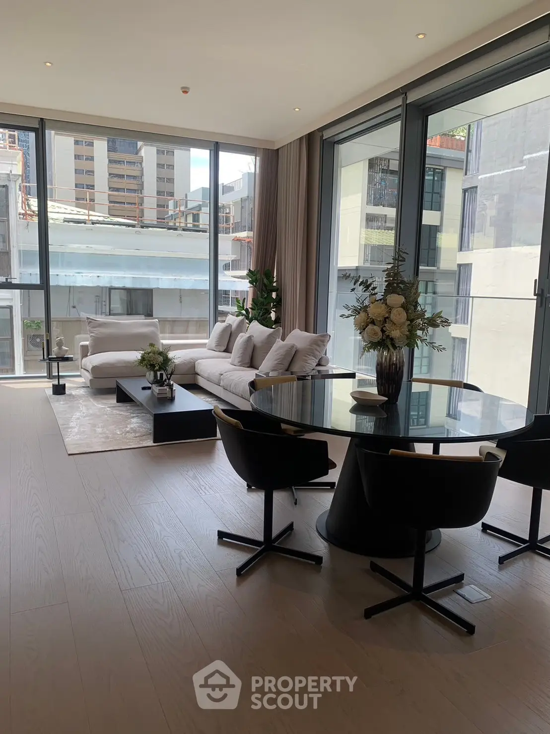Luxurious modern living room with floor-to-ceiling windows and elegant furnishings in a high-rise apartment.