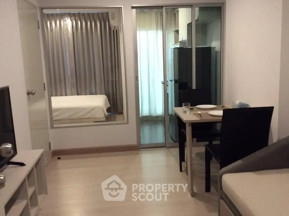 Modern apartment interior with open layout, featuring a cozy dining area and a glimpse into the bedroom.