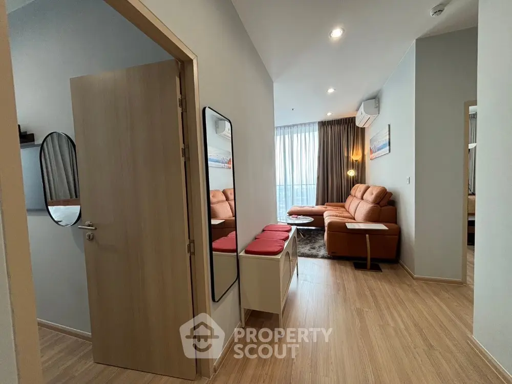 Modern apartment entrance with stylish living room and wooden flooring