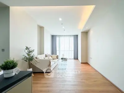Spacious modern living room with elegant wooden flooring and natural light.