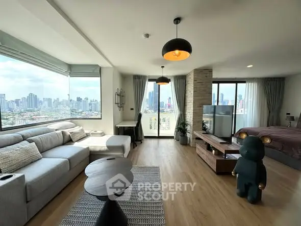 Spacious modern living room with city view, open layout, and stylish decor in high-rise apartment.