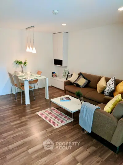 Modern living room with stylish decor and dining area, featuring hardwood floors and cozy seating.