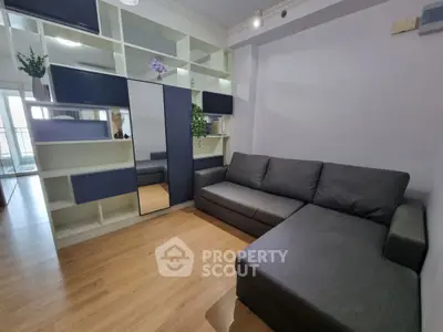 Modern living room with sleek gray sectional sofa and stylish shelving unit