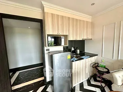 Modern compact kitchen with sleek cabinetry and appliances in a stylish apartment.