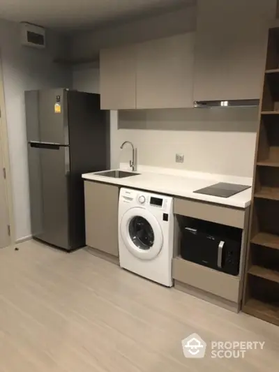 Modern kitchen with integrated appliances including washing machine and fridge