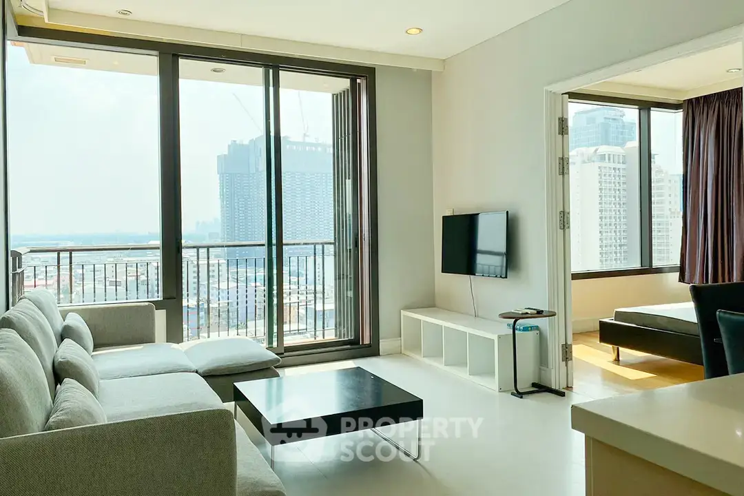 Modern living room with large windows and city view, adjacent to a cozy bedroom.