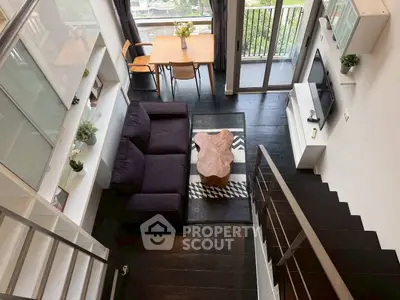 Modern loft-style living room with dark wood floors and stylish furniture