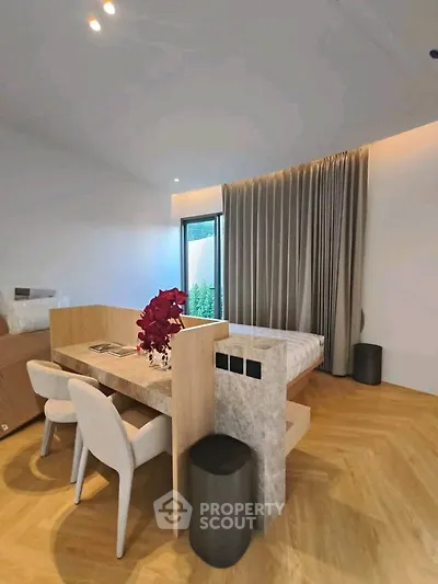 Modern bedroom with stylish decor and natural light, featuring a cozy workspace and elegant furnishings.