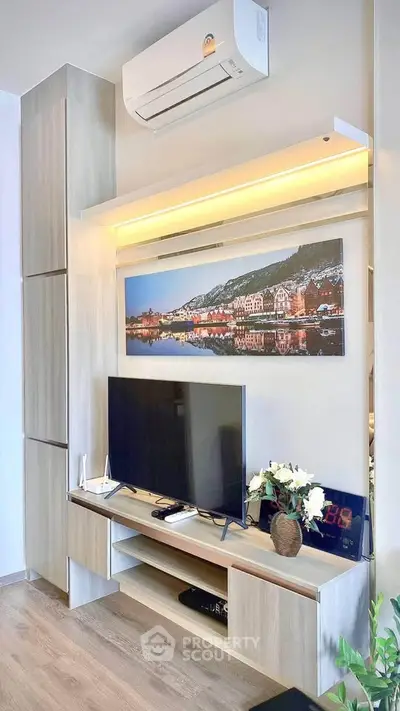 Modern living room with sleek TV unit and air conditioning, featuring stylish decor and warm lighting.