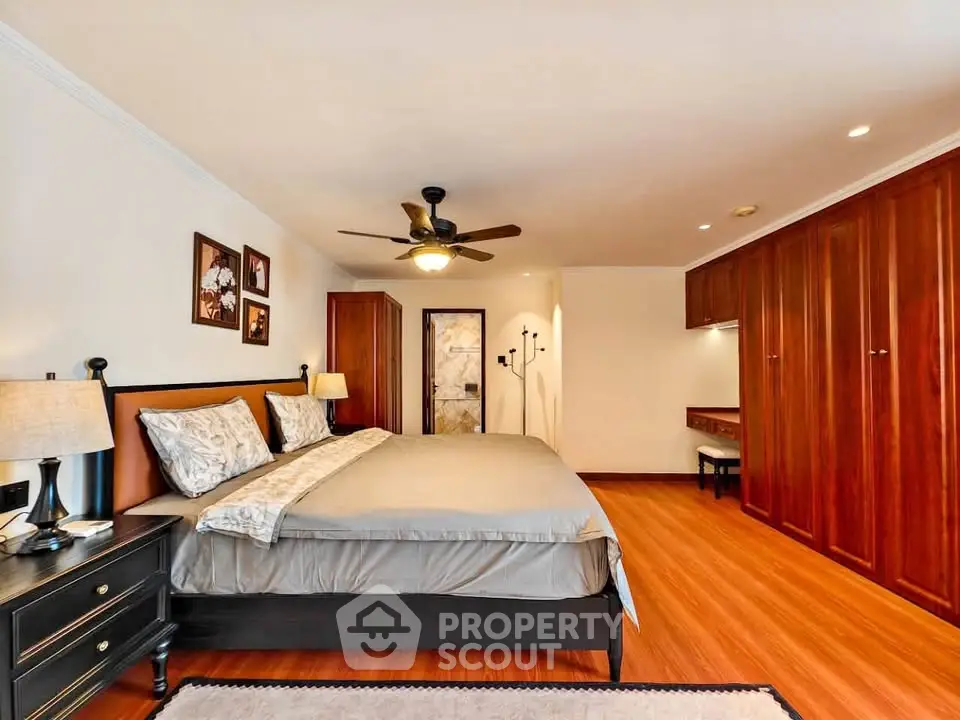 Spacious bedroom with elegant wooden flooring and ample closet space