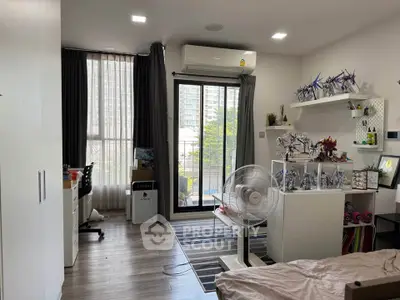 Modern bedroom with balcony and stylish decor, featuring air conditioning and ample natural light.