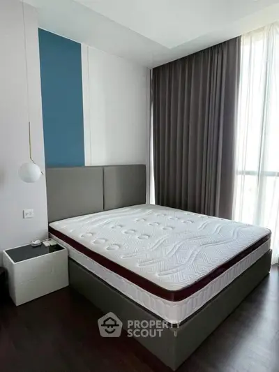 Modern bedroom with stylish decor and large window for natural light