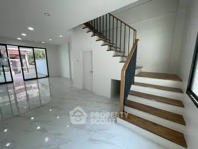 Spacious modern living room with elegant staircase and large windows