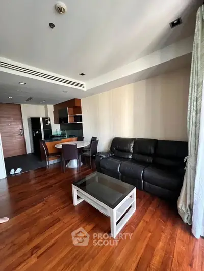 Spacious living room with modern furniture and open kitchen layout.