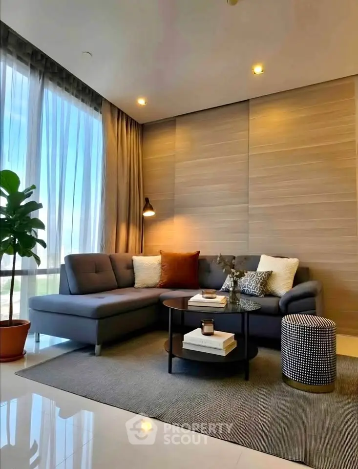 Modern living room with stylish decor and large windows offering natural light.