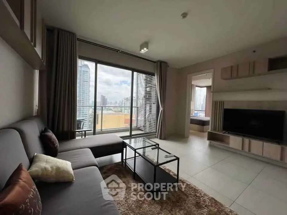 Spacious modern living room with city view and large balcony access.