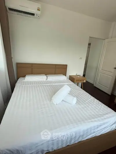 Cozy bedroom with modern air conditioning and minimalist decor in a stylish apartment.