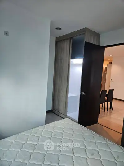 Cozy bedroom with built-in closet and partial view of dining area